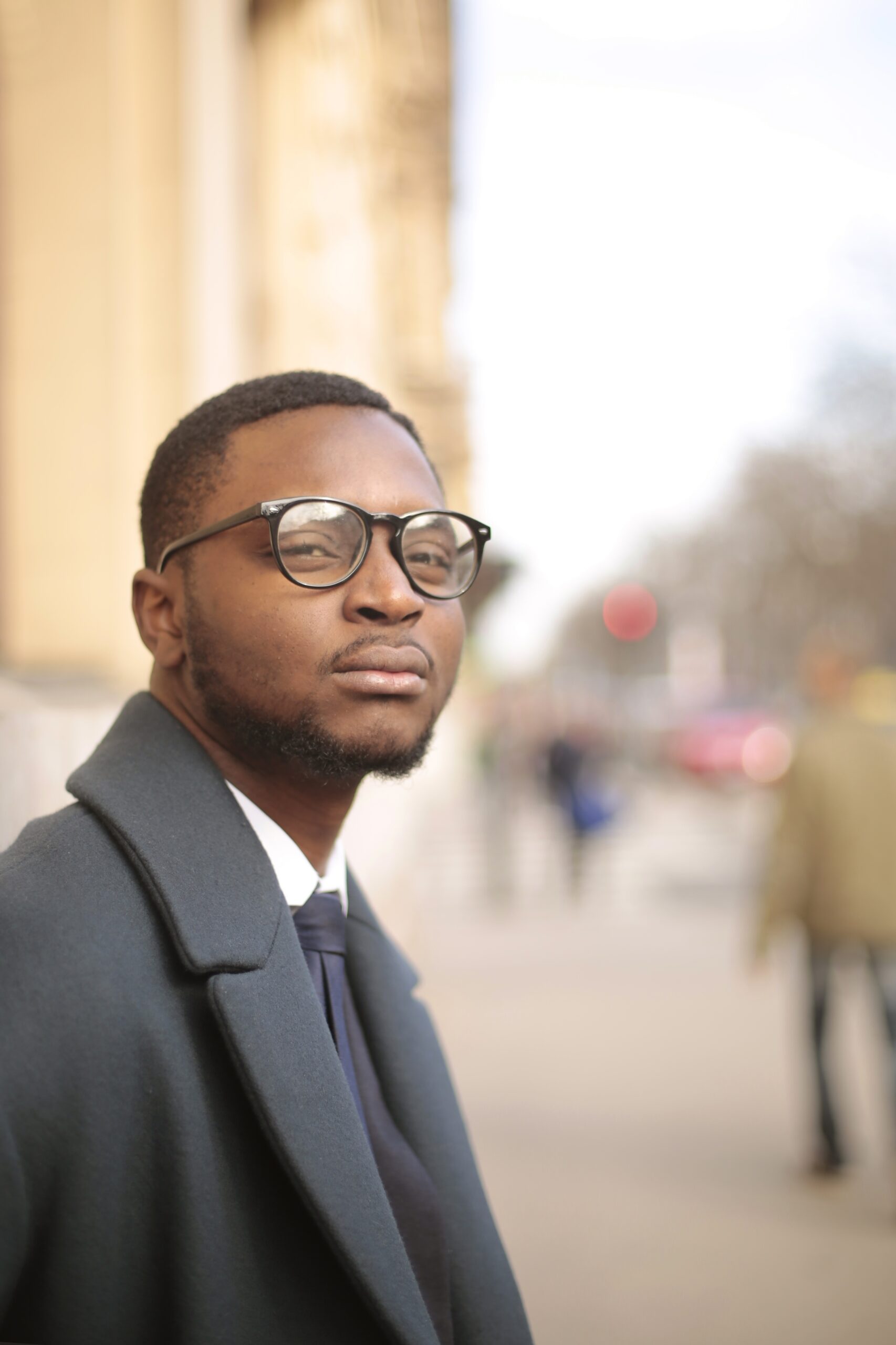 A vertical shot of a well dressed African American male looking at the camera